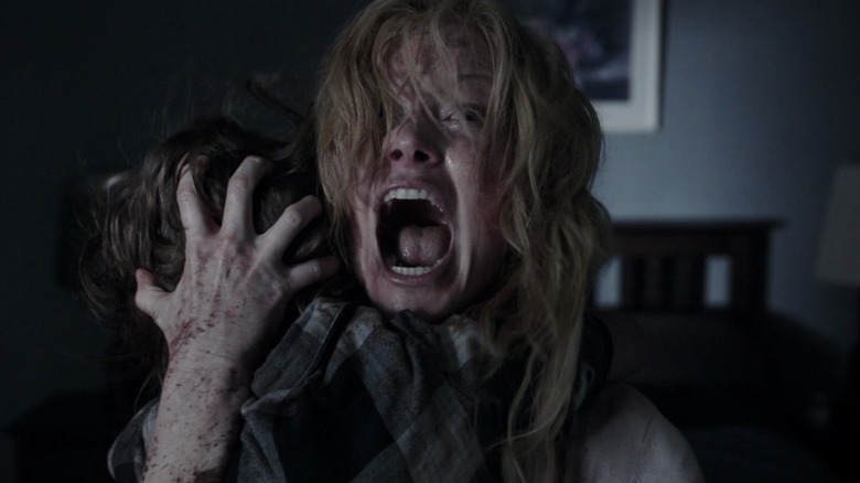 Amelia Vanek (Essie Davis) screaming while holding her son in The Babadook