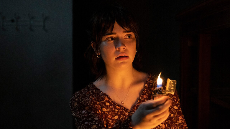 Sophie Thatcher as Sadie tries to see in the dark with a lighter in The Boogeyman