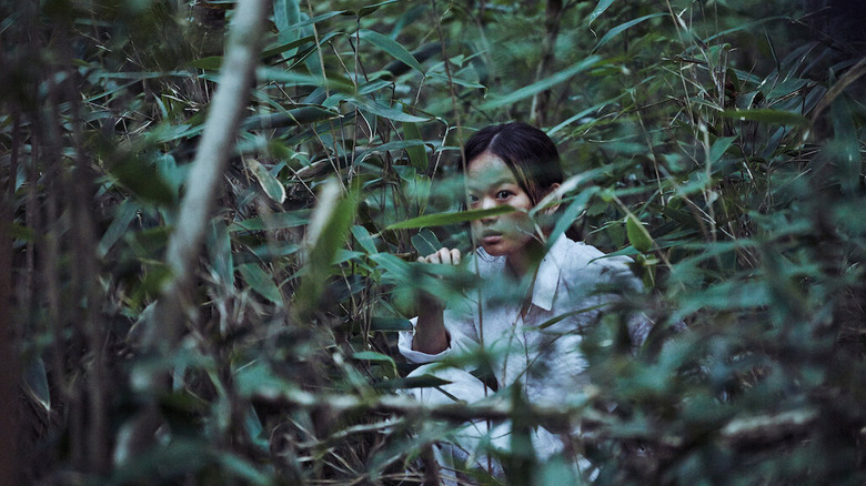 Chun Woo-hee as Moo-myeong, hiding and watching in The Wailing