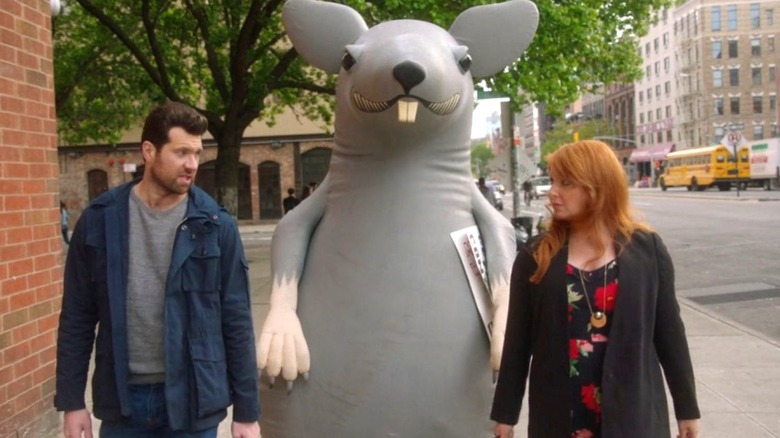 Billy Eichner as Billy Epstein and Julie Klausner as Julie Kessler walk an inflatable rat down the sidewalk on Difficult People