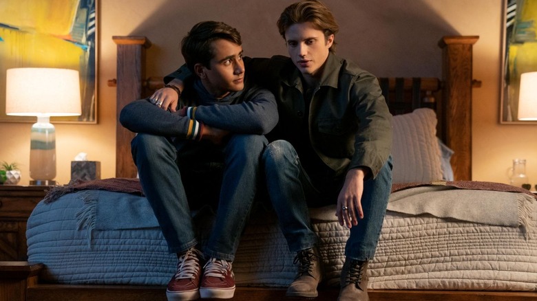 Michael Cimino as Victor and George Sear as Benji sit on the edge of a bed together on Love, Victor