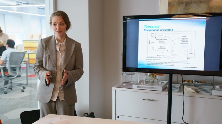Amanda Seyfried as Elizabeth Holmes stands as she presents the findings of Theranos on The Dropout