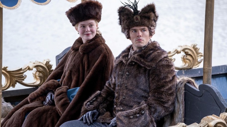 Elle Fanning as Catherine sits next to Nicholas Hoult as Peter while in a carriage on The Great