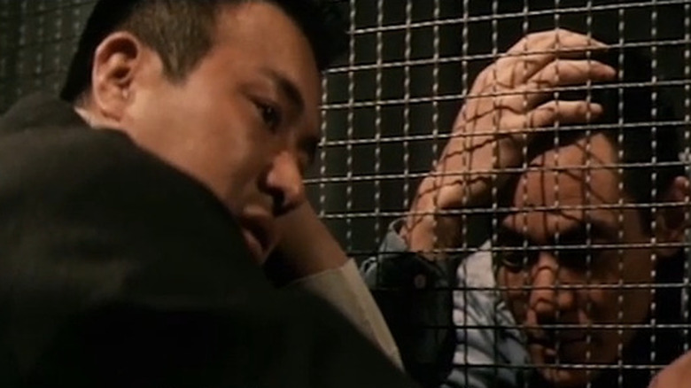 Men talking through metal grating in Battle Without Honor or Humanity