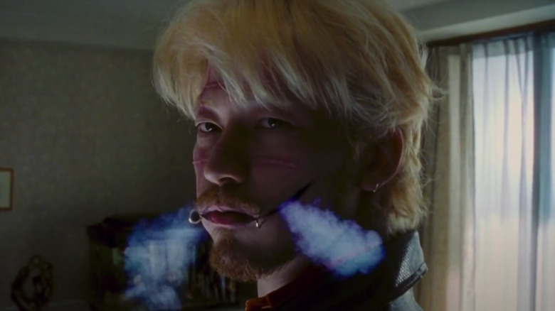 Tadanbu Asano blowing smoke through perforated cheeks