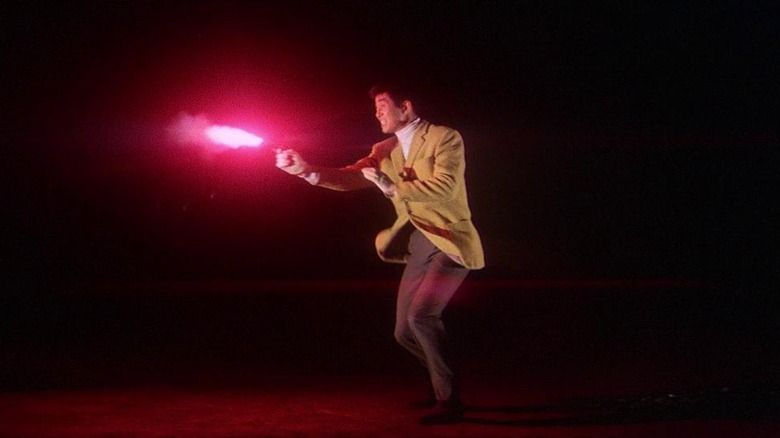 Tetsuya Watari firing a gun