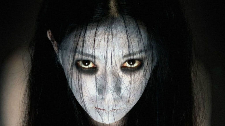 A young woman in white face paint grudge