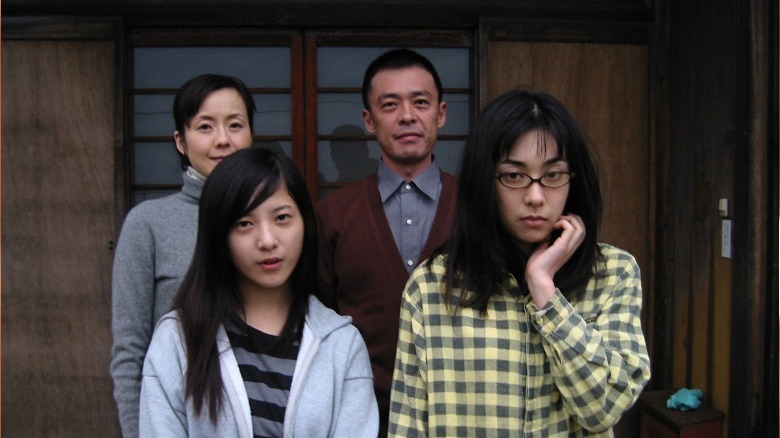 noriko poses with fake family in Noriko's Dinner Table