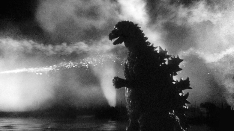 Godzilla stands framed by fire and smoke on the bay in Godzilla (1954)