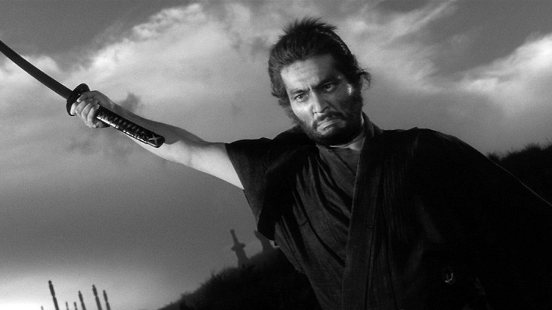 Tsugumo Hanshirō (Tatsuya Nakadai) draws his sword on a grassy hill in Harakiri (1962)