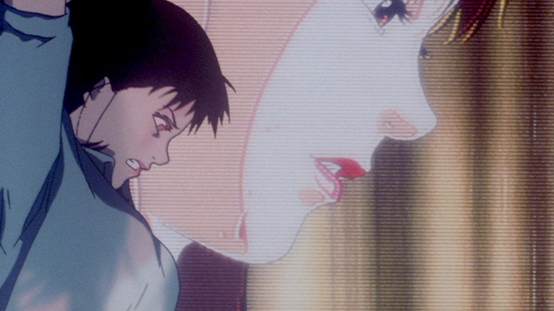 Mima Kirigoe prepares to stab downward in front of a large photo of herself in Perfect Blue