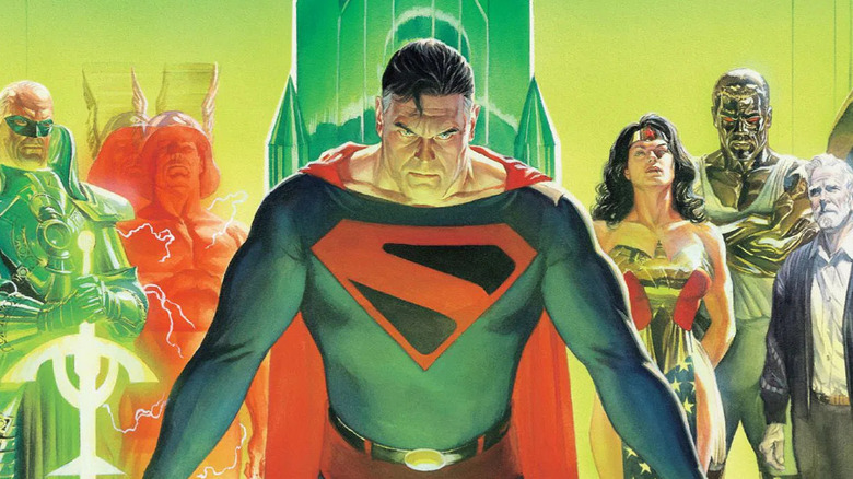 Superman stands sternly at a table with Norm McCray and the Justice League behind him on the cover of Kingdom Come Deluxe Edition