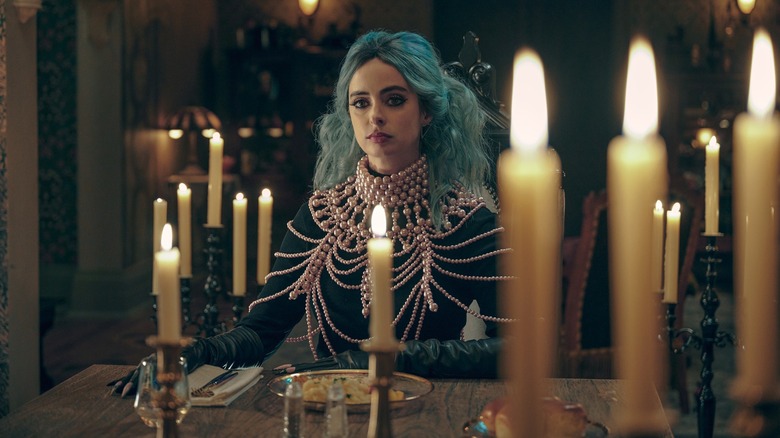 Krysten Ritter's Natacha sitting at the table in Nightbooks