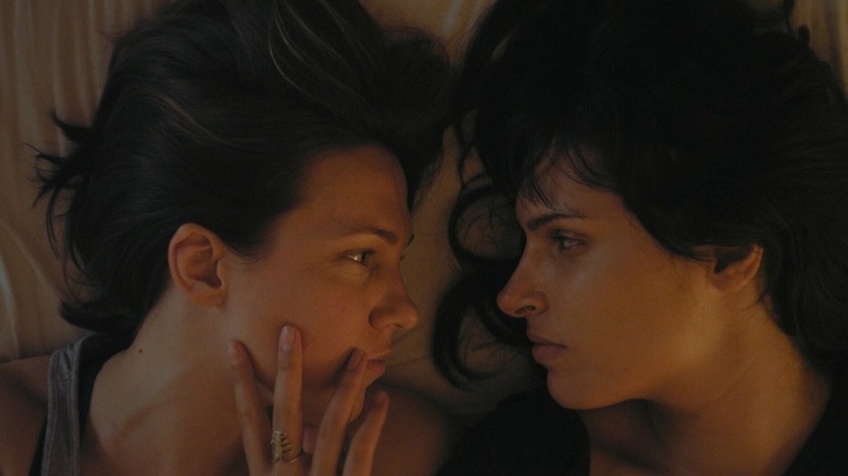 Woman holds another woman's face