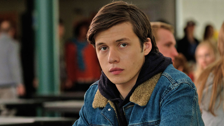A boy looks at something offscreen