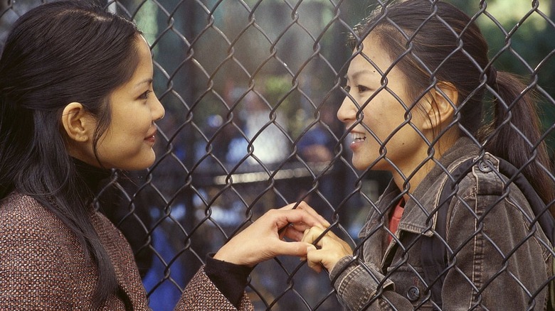 Two women hold hands