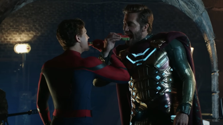 Tom Holland and Jake Gyllenhaal eating watermelon in costume with interlocked arms in Spider-Man Far From Home