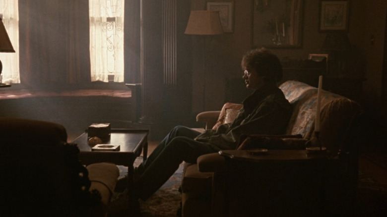 Jacob (Tim Robbins) sitting on couch in Jacob's Ladder