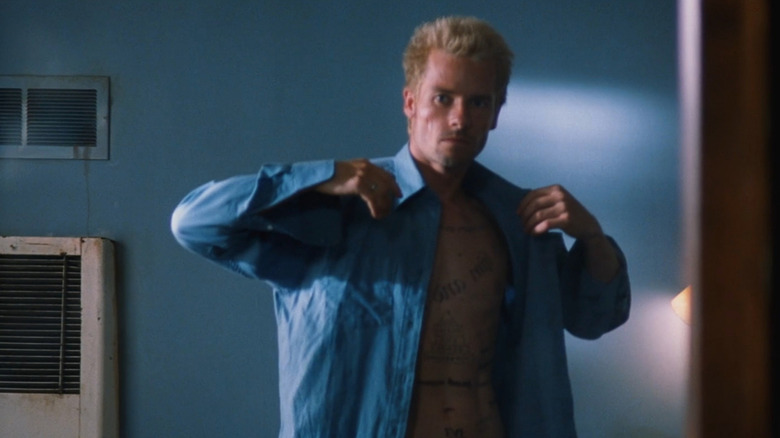 Leonard (Guy Pearce) putting on shirt in Memento