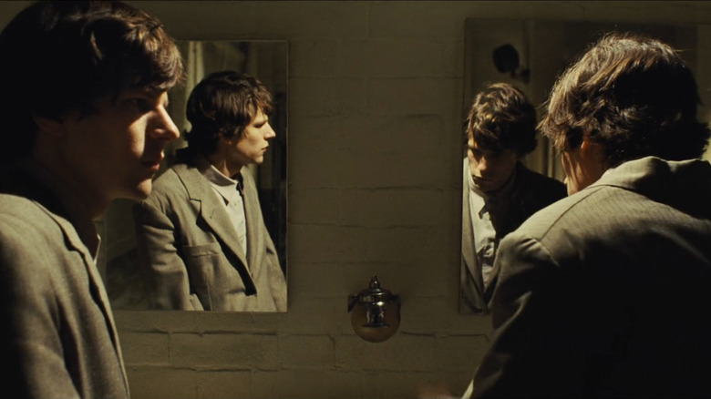 James and Simon (Jesse Eisenberg) standing in front of mirrors in The Double