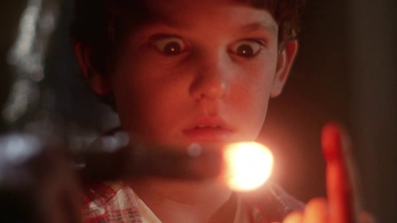 Henry Thomas as Elliott in ET, looking at ET's lit-up finger pointed as his own