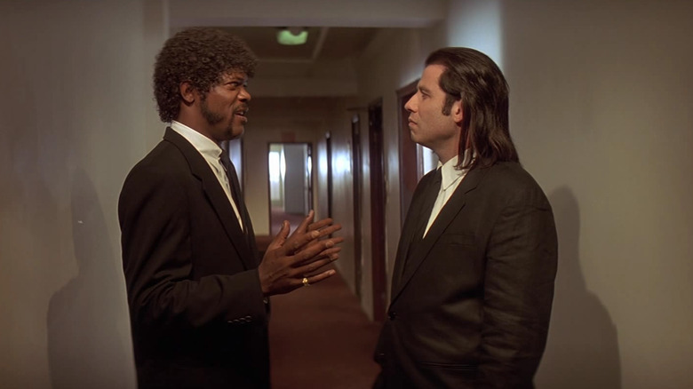 John Travolta as Vincent Vega and Samuel L Jackson as Jules, standing in a hallway in Pulp Fiction
