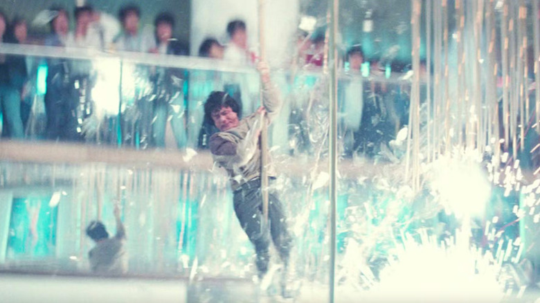 Jackie Chan sliding down pole while sparks explode all around him in Police Story