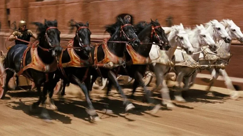 Four black horses and four white horses racing with chariots, with Stephen Boyd as Messala riding chariot with black horses in Ben-Hur