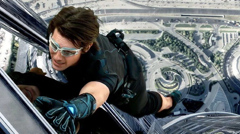 Tom Cruise as Ethan Hunt in protective glasses and gloves climbing high up the Burj Khalifa in Mission: Impossible – Ghost Protocol
