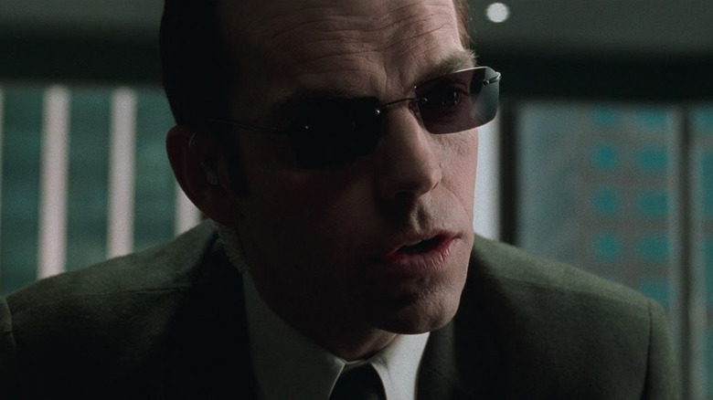 Hugo Weaving's Agent Smith wearing sunglasses and interrogating Morpheus in The Matrix
