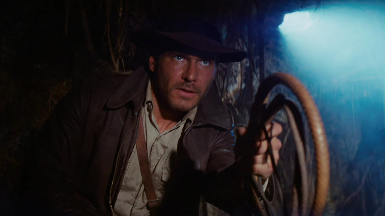 Harrison Ford as Indiana Jones offering up his whip for use in Raiders of the Lost Ark