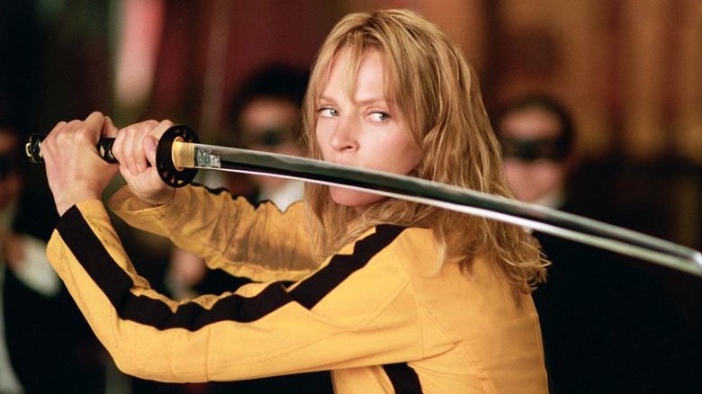 Uma Thurman as The Bride, also known as Beatrix Kiddo, holding a sword up as she prepares for battle in Kill Bill: Volume I