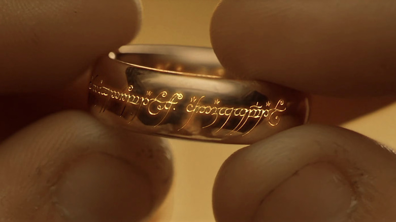 The One Ring in Frodo Baggins' fingers in Lord of the Rings: Fellowship of the Ring