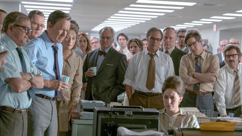 News team gathers around radio