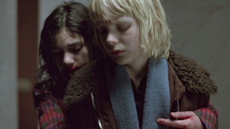 Eli (Lina Leandersson) hugs Oskar (Kåre Hedebrant) from behind in Let the Right One In