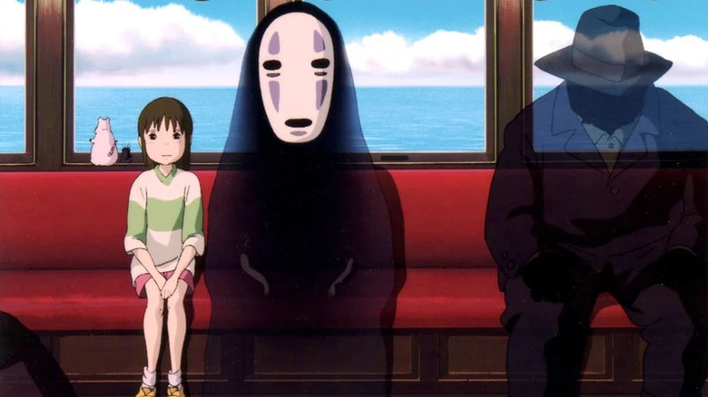 Chihiro Ogino sits next to No-Face on a train in Spirited Away