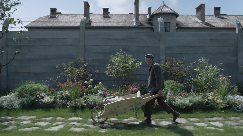 a prisoner doing yard work, in The Zone of Interest