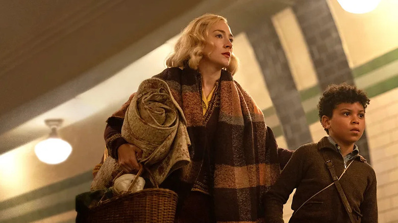 Saoirse Ronan as Rita and Elliott Heffernan as George walking through train station in Blitz