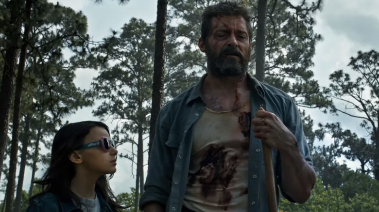 Dafne Keen as Larua and Hugh Jackman as Wolverine burying Charles Xavier in Logan