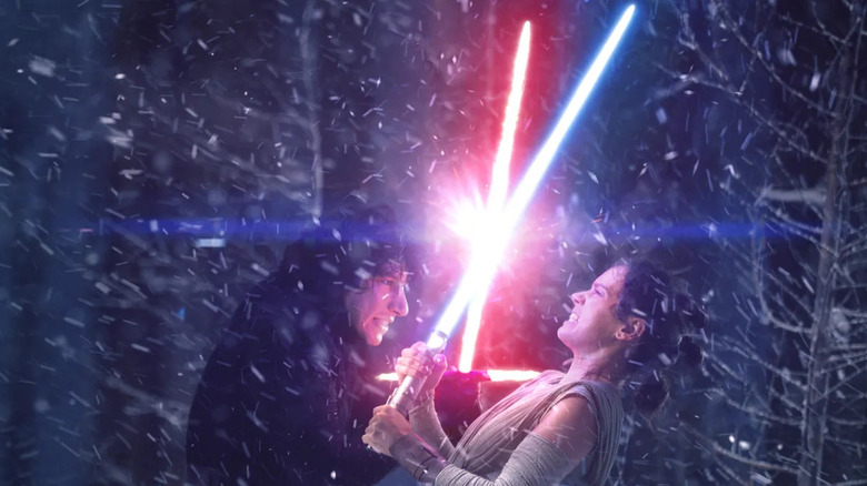 Kylo Ren (Adam Driver) and Rey (Daisy Ridley) duel with lightsabers in Star Wars: The Force Awakens