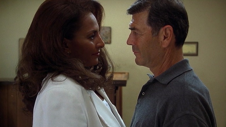 Pam Grier as Jackie Brown and Robert Forster as Max Cherry in Jackie Brown, standing closely and looking at each other.