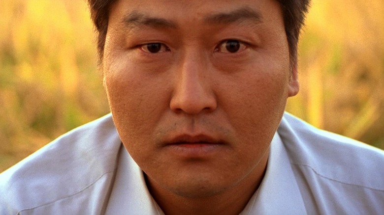 Song Kang-ho as Park Doo-man in Memories of Murder, looking right into the camera.