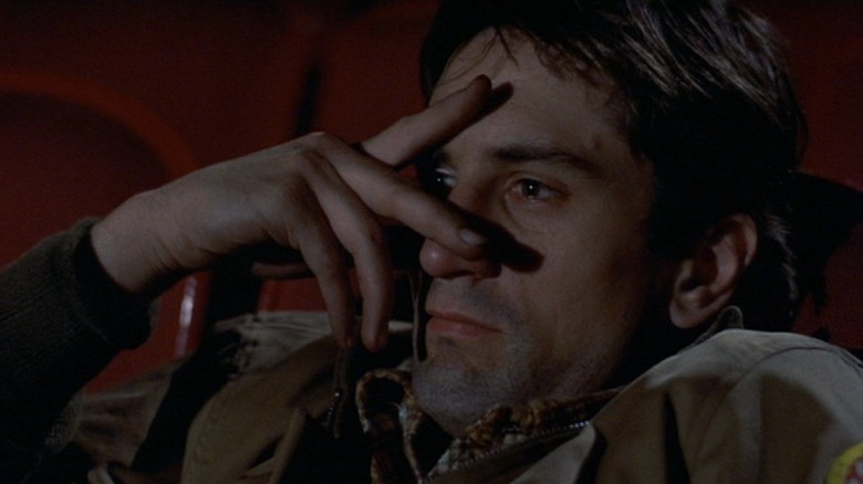 Robert De Niro as Travis Bickle peeking through his fingers in Taxi Driver.