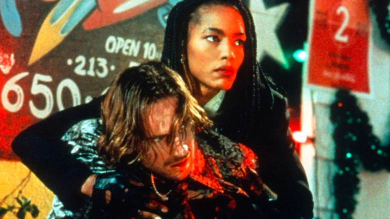 Ralph Fiennes as Lenny and Angela Bassett as Mace with arms around him from behind in Strange Days