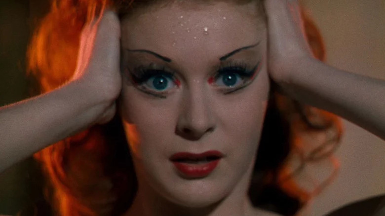 Close-up of Moira Shearer as Victoria in stage makeup with hands on the side of face in The Red Shoes