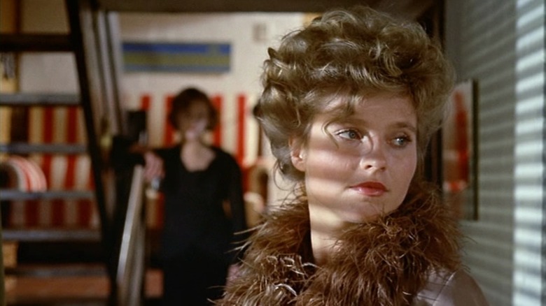 Margit Carstensen as Petra von Kant, standing dramatically against a shadowy wall, in The Bitter Tears of Petra von Kant