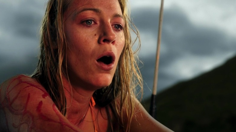 A sunset-lit, bloody Blake Lively as Nancy looking scared in The Shallows