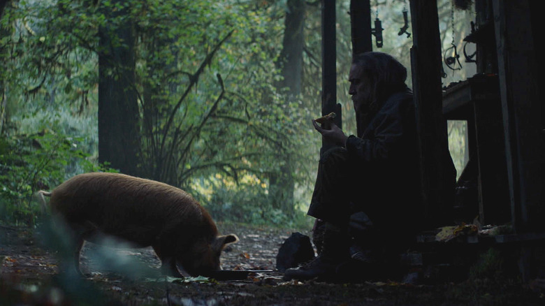 Nicolas Cage as Rob, enjoying a meal with his pig in Pig