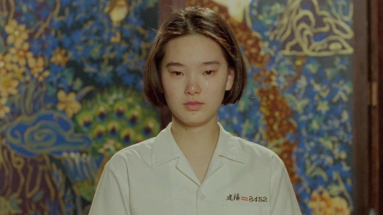 Lisa Yang as Ming crying in front of a flower print wall in A Brighter Summer Day