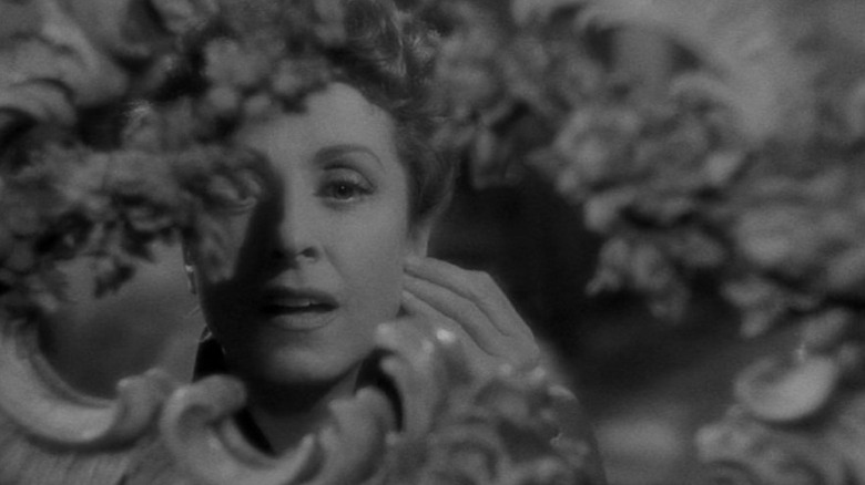 Daniellee Darrieux as Countess Louise de... looking at herself in a heavily ornamented mirror in The Earrings of Madame de...